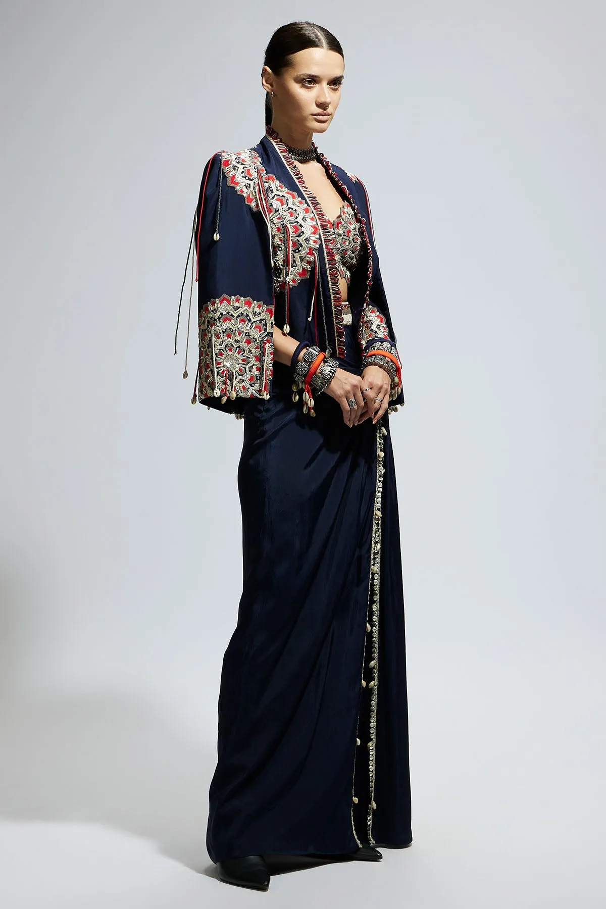 Blue Asymetric Threadwork Cape Jacket Paired with An Embellished Bustier and High Slit Skirt